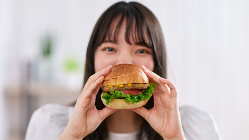 ハンバーガーを食べる女性